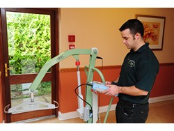An Independent Healthcare Service engineer using the Rigel Medical 288 to test the electrical safety of a powered lift