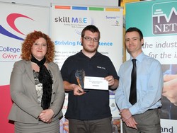 SkillELECTRIC Wales winner Daniel Hughes receives his trophy from Vice Principal of Gower College Kay Morgan and Mark Bradley from the Welsh Government